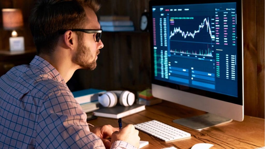 A man looking at graphs and data on a computer screen