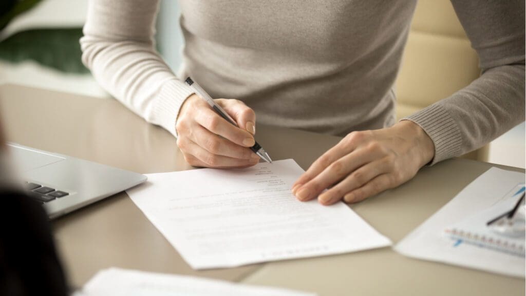 A woman signing some paperwork