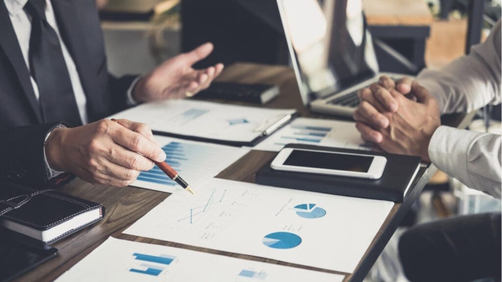 Two people reviewing financial data and graphs