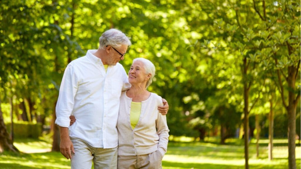 An older couple walking through a park