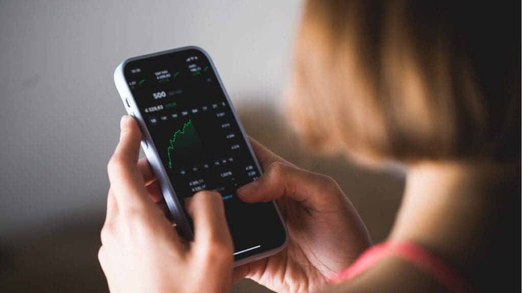 a woman looking at investments on her phone